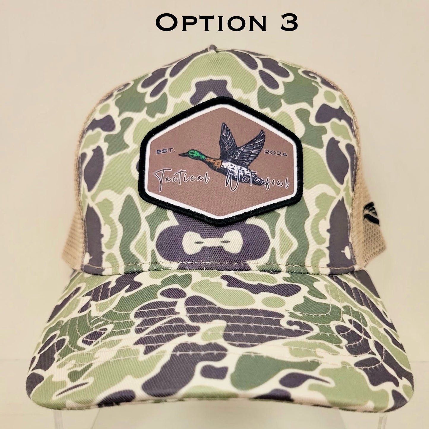 Camouflage cap with a patch featuring a duck on a beige background