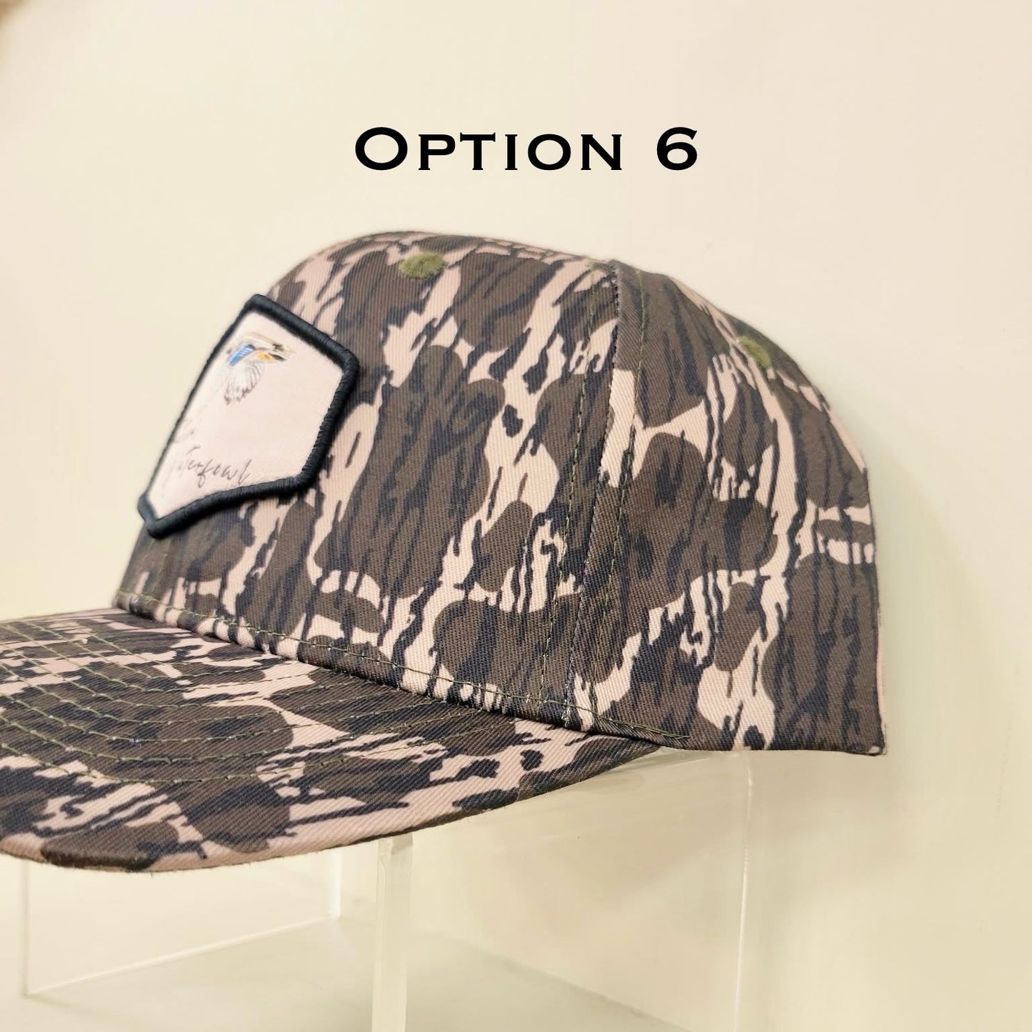 Camouflage-patterned cap on a clear stand with 'Option 6' text above.